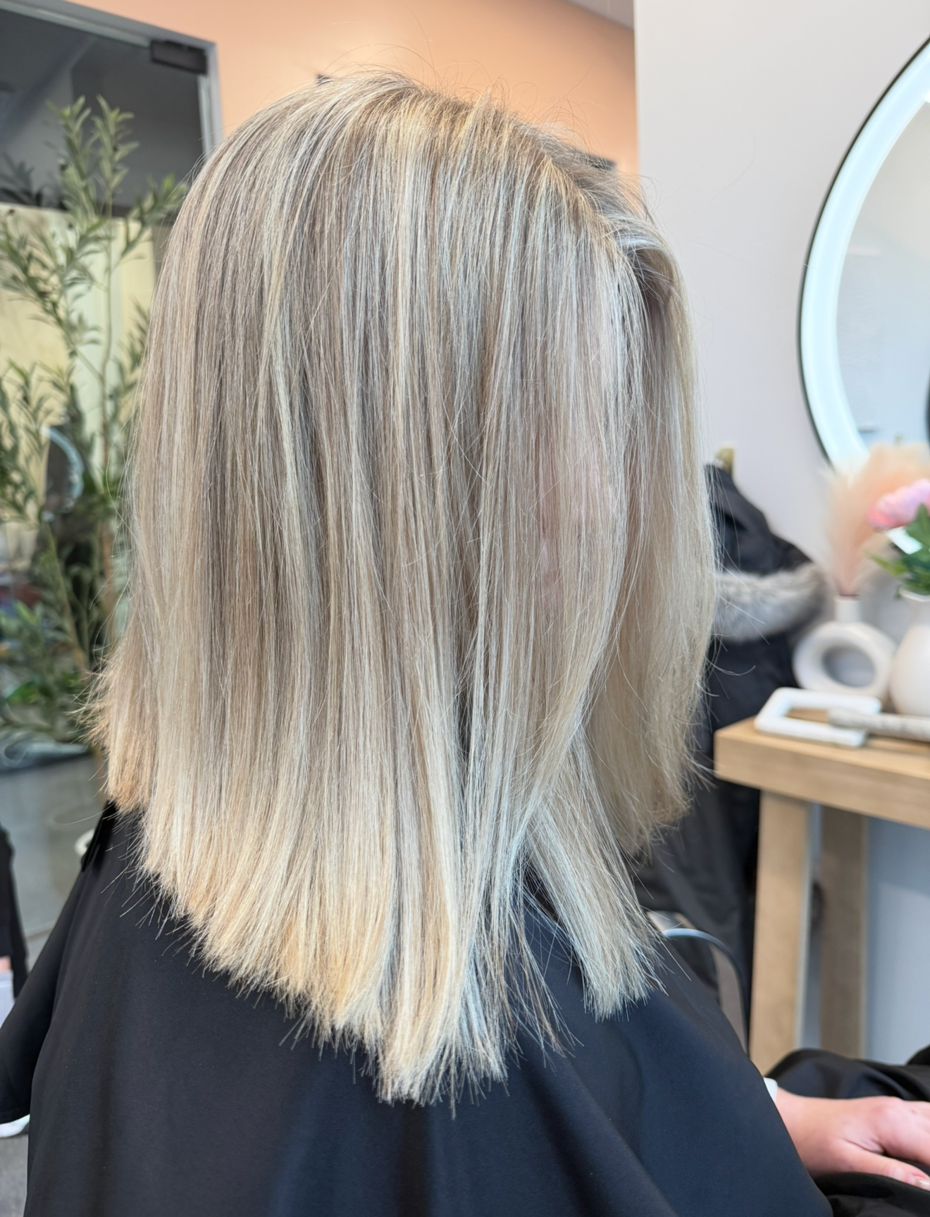 Blonde hair, straight and shoulder length, at a salon.