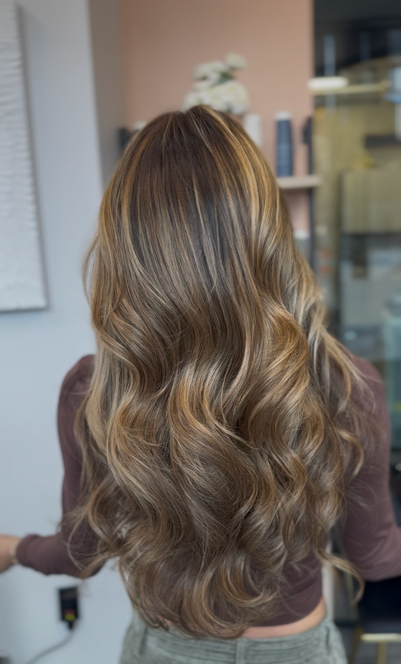 Woman's brown and blonde crimped hair styled in waves, a salon setting.