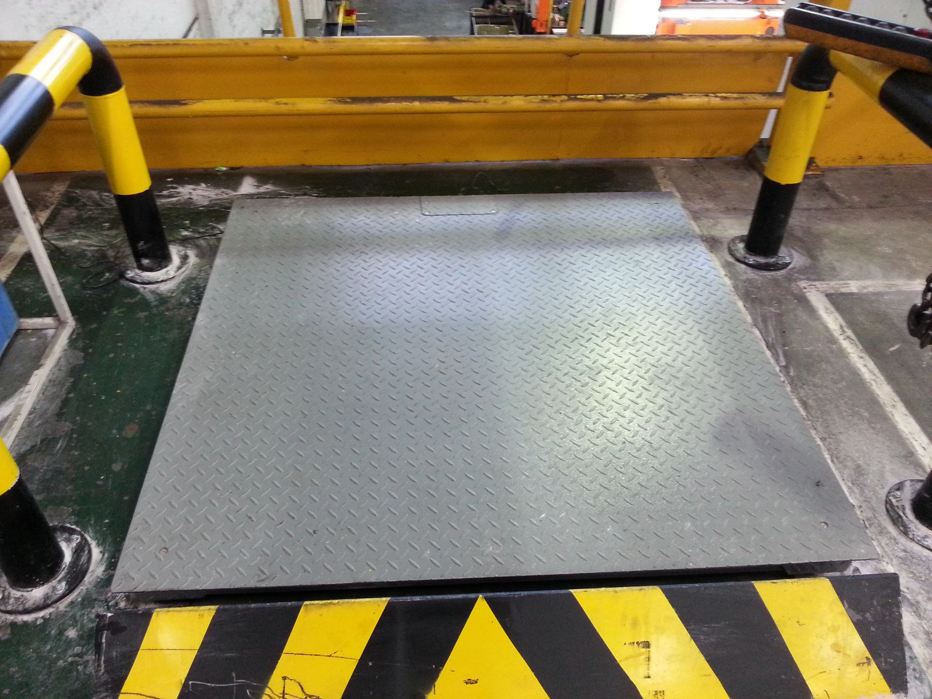 A yellow and black striped floor with a warning sign