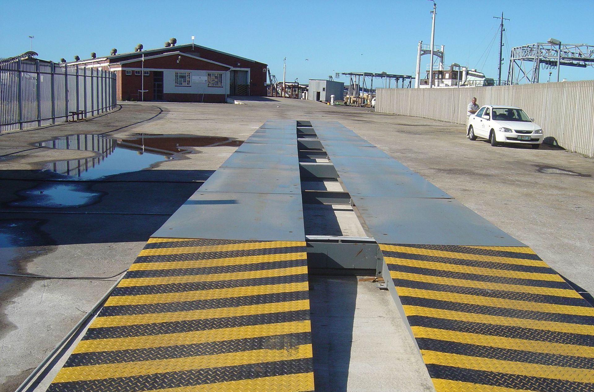 A car is parked on the side of the road next to a scale