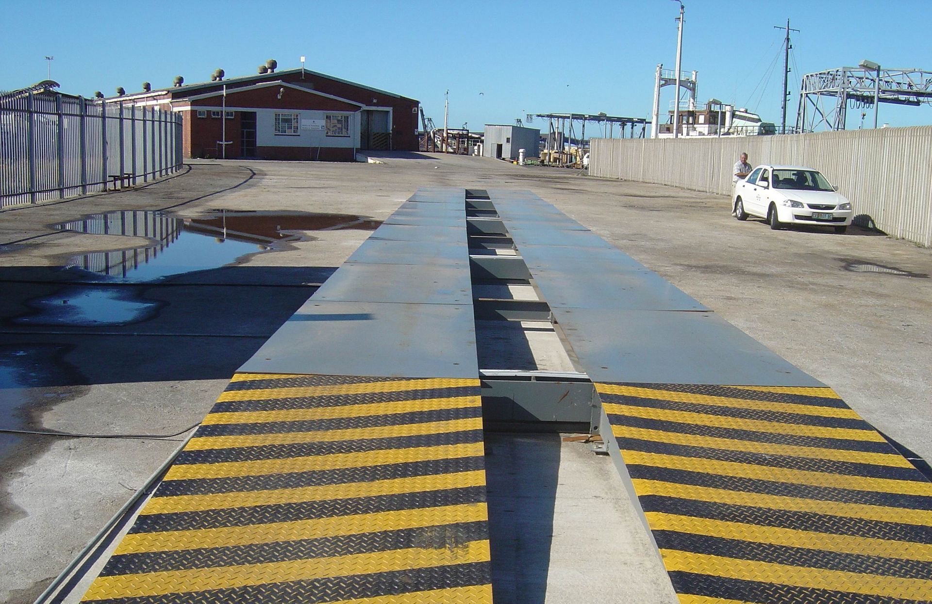 A white car is parked on the side of a road