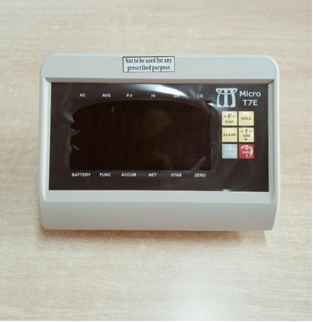 A micro t7e device is sitting on a wooden table