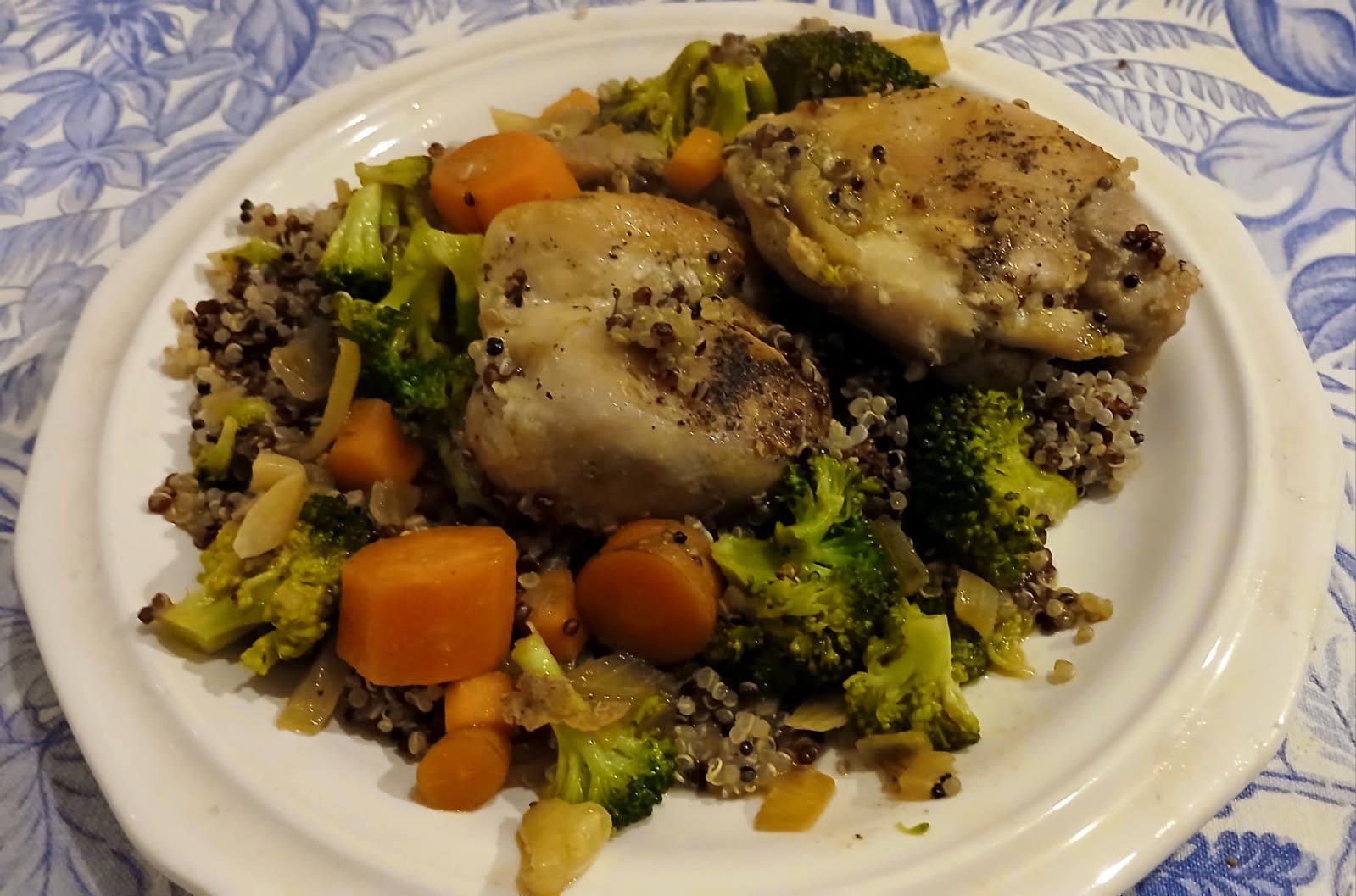 A white plate topped with chicken , broccoli , carrots and rice.