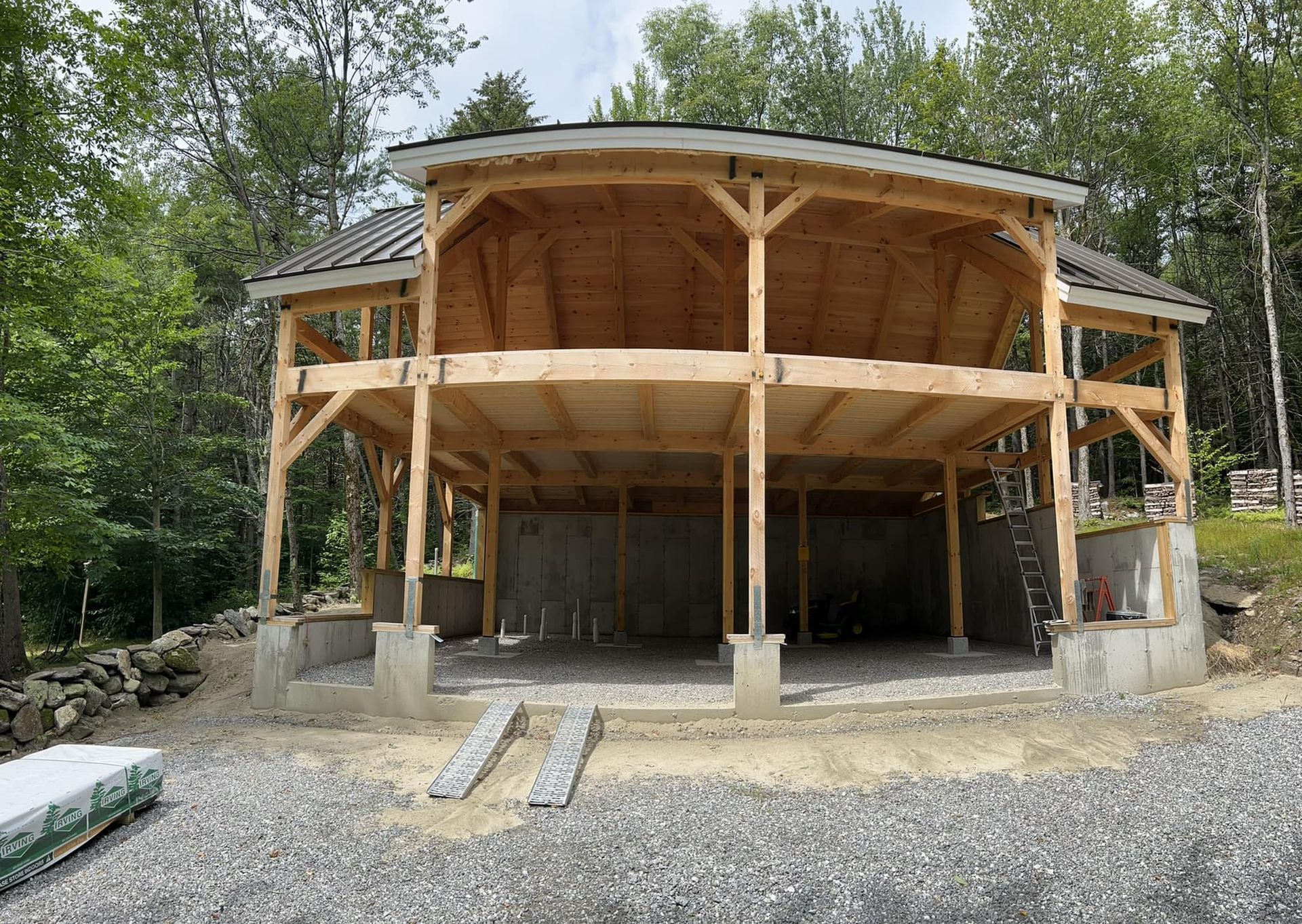 A large wooden structure is being built in the middle of a forest.