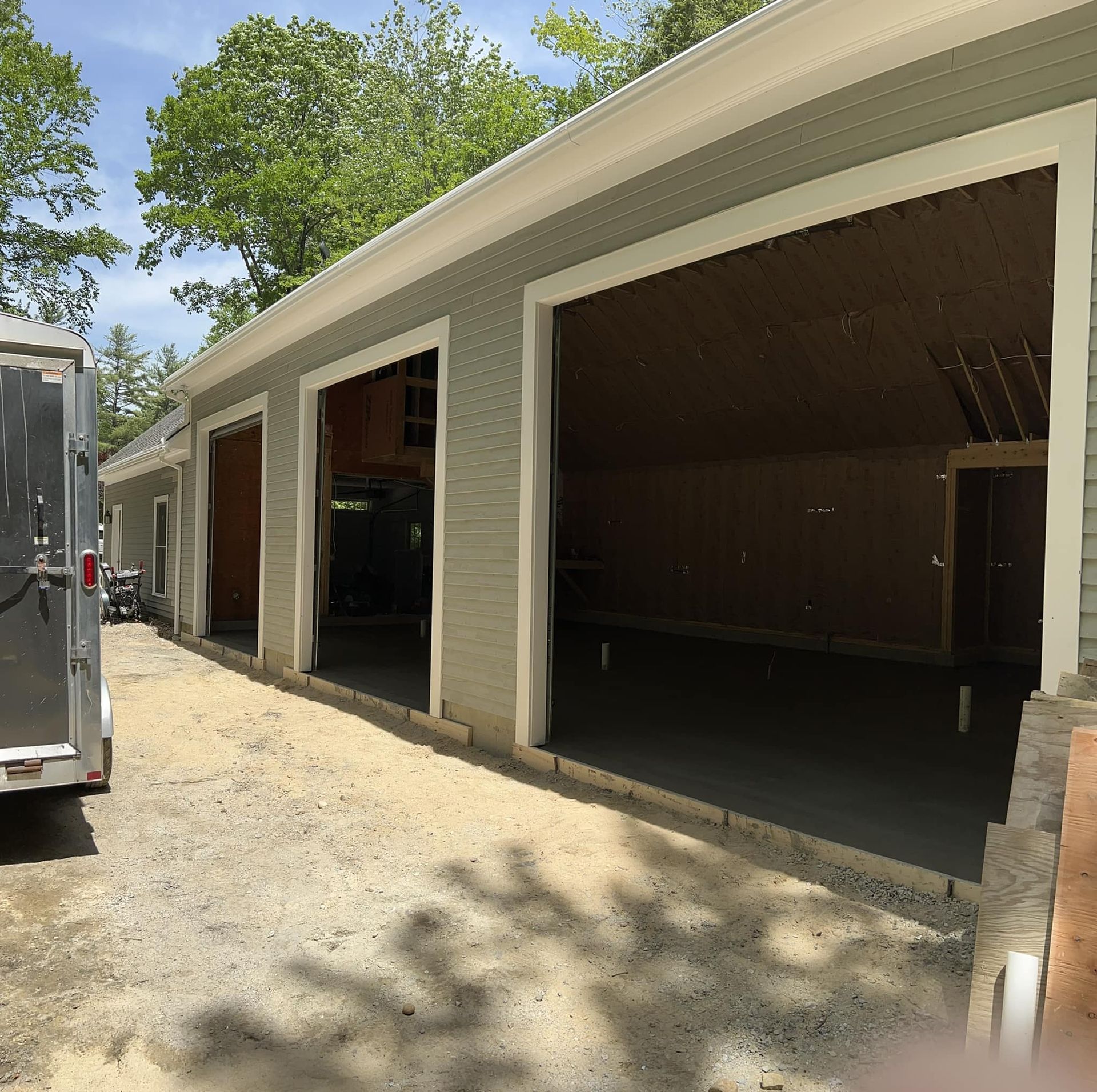 A trailer is parked in front of a garage under construction