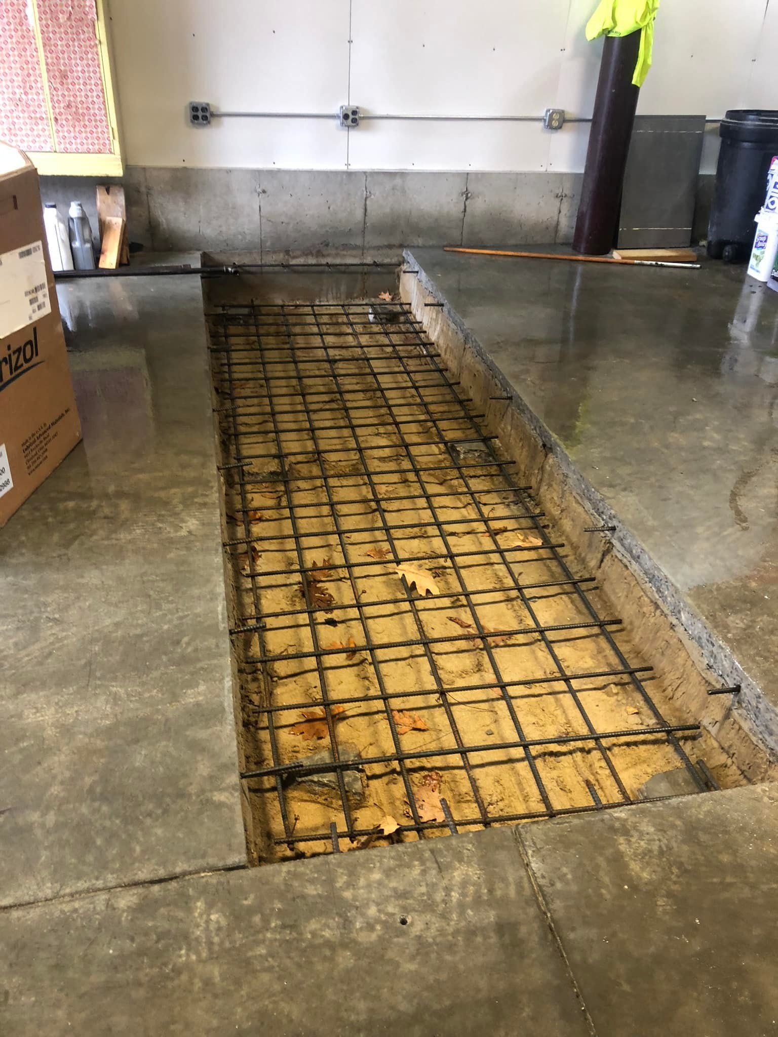 A hole in the floor is being filled with concrete.