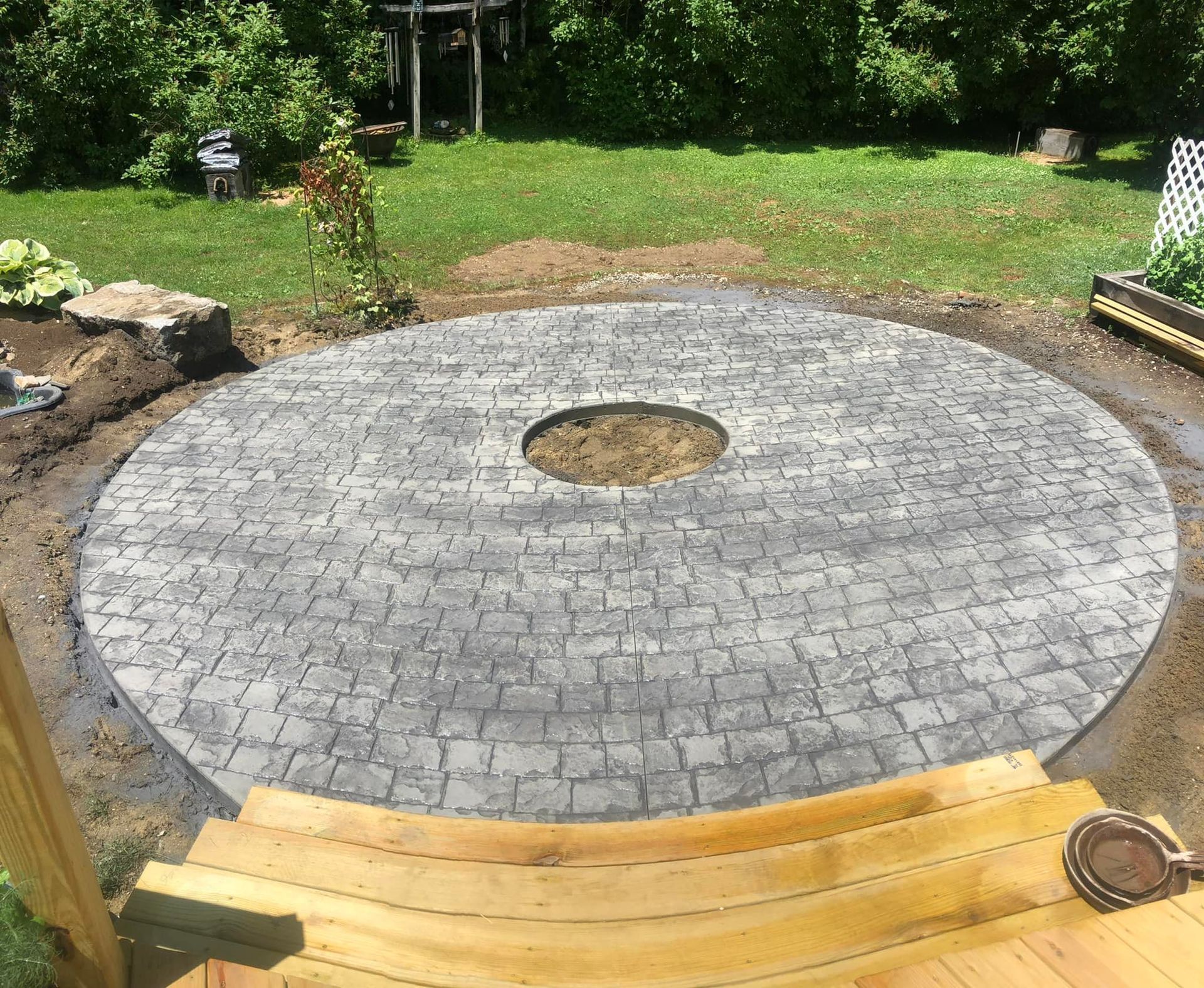 A circular patio with a fire pit in the middle of it