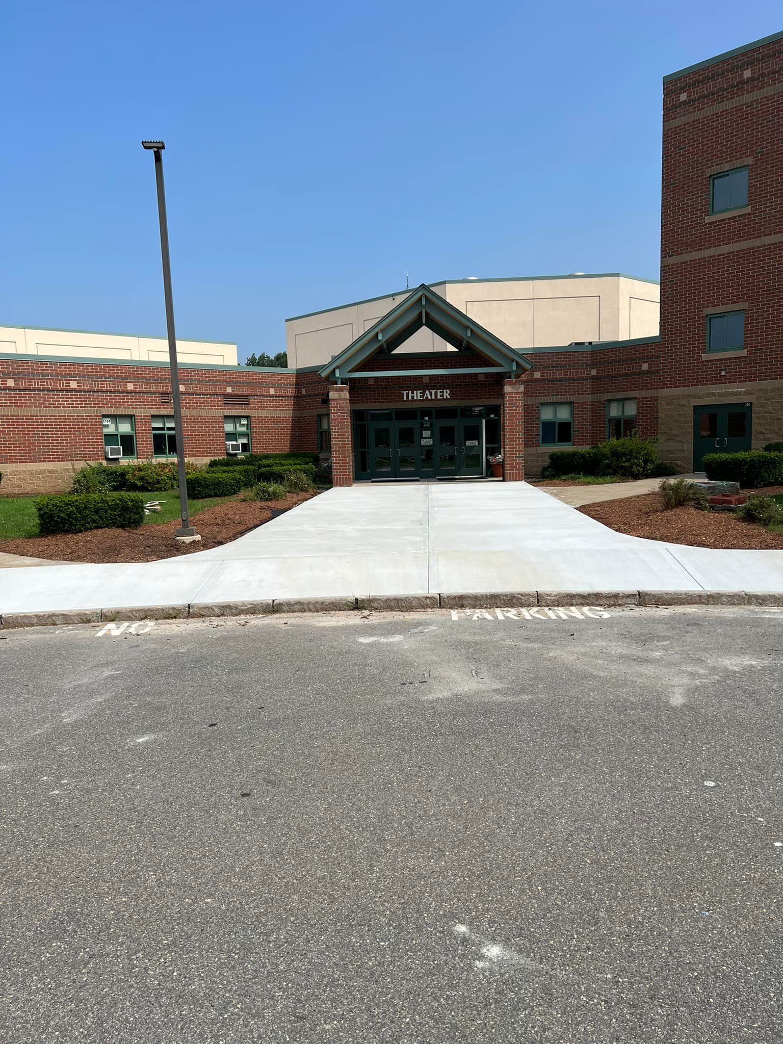 A brick building with a concrete walkway leading to it