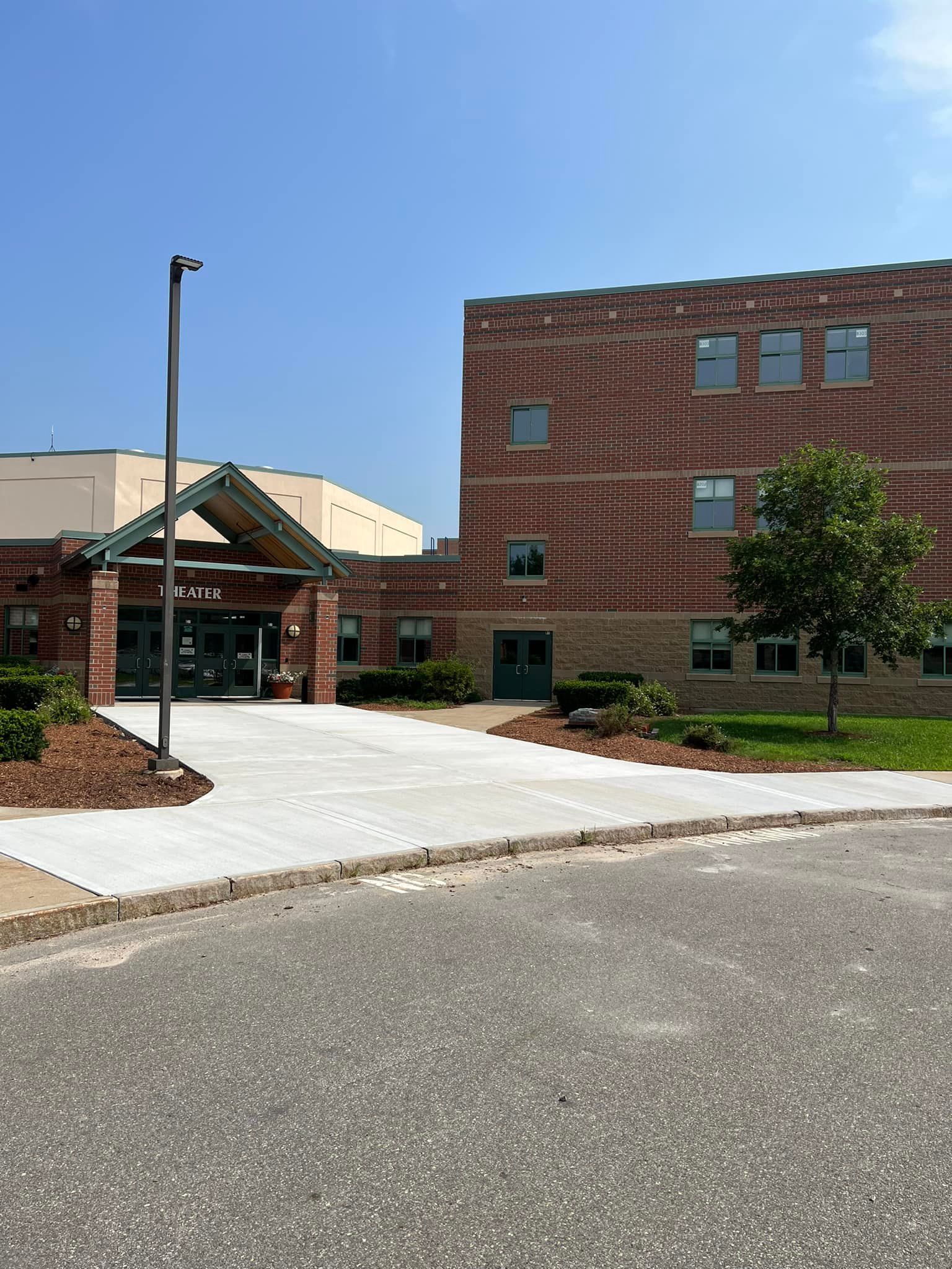 A large brick building with a concrete walkway leading to it