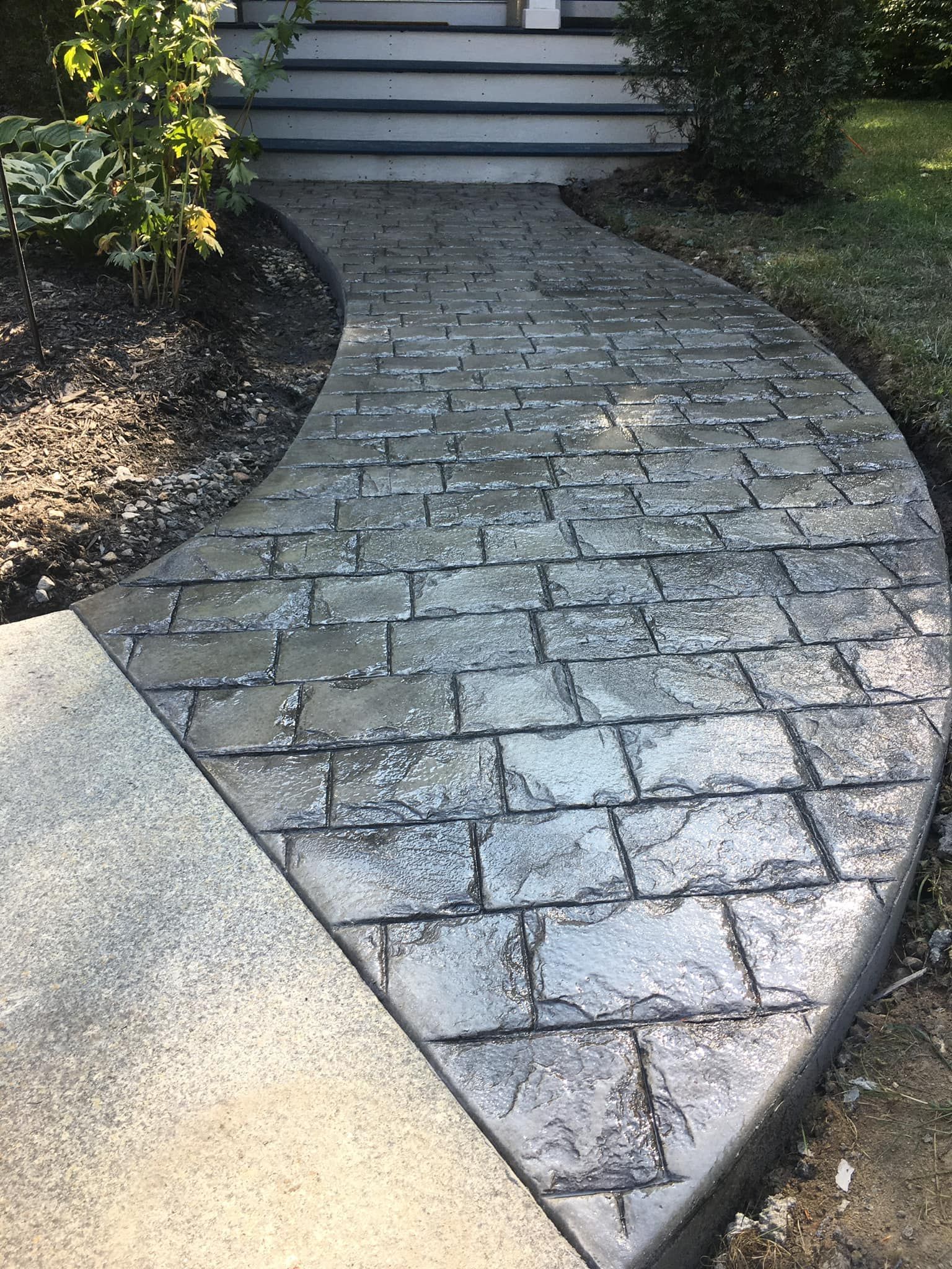 A brick walkway leading to the front door of a house.