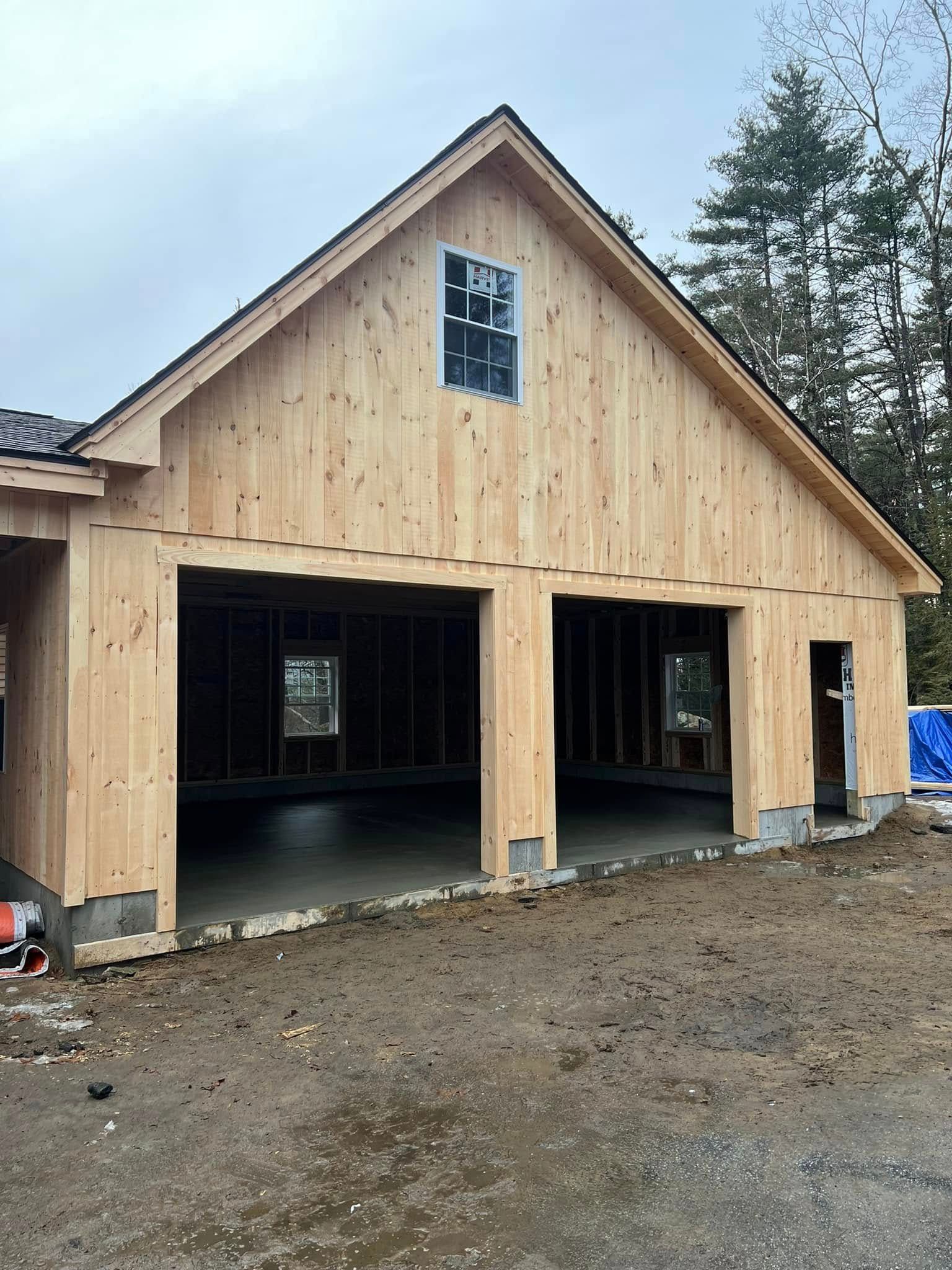 A wooden garage under construction with the doors open