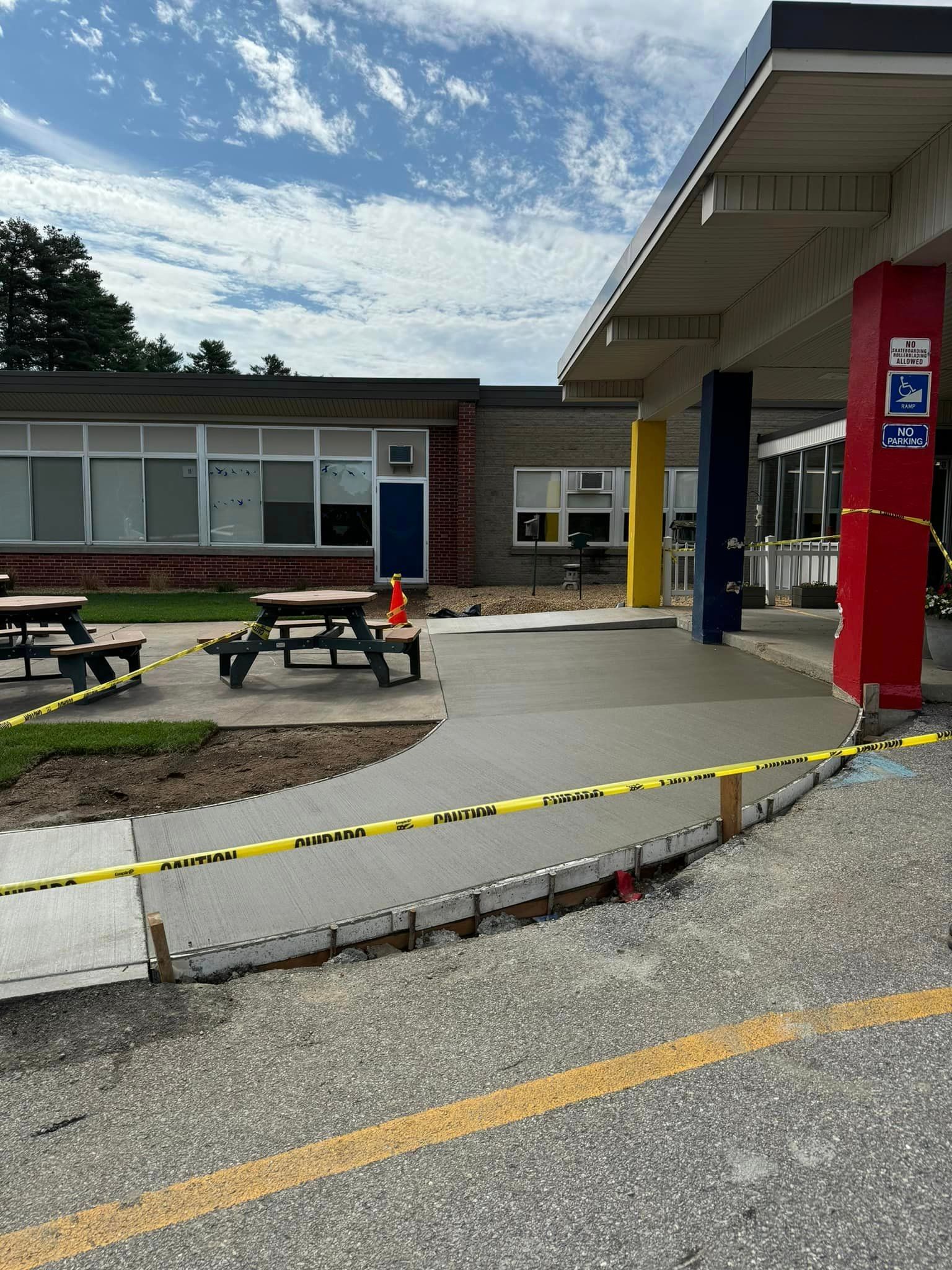 A concrete walkway is being built in front of a school