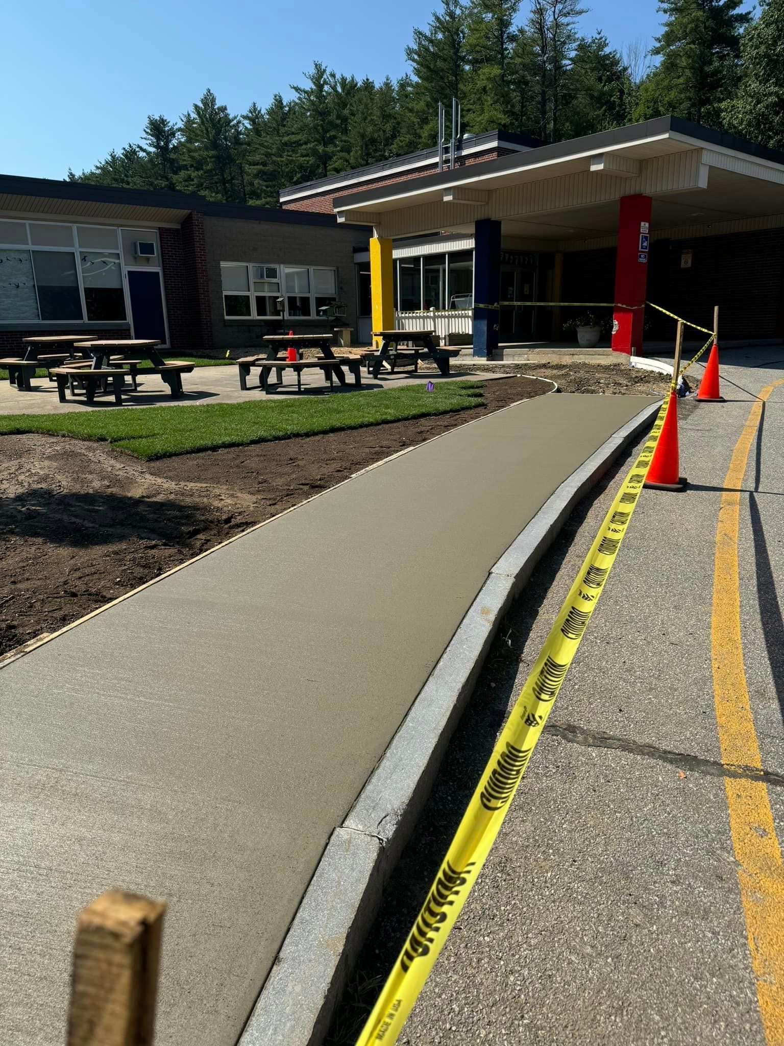 A concrete walkway is being built in front of a school