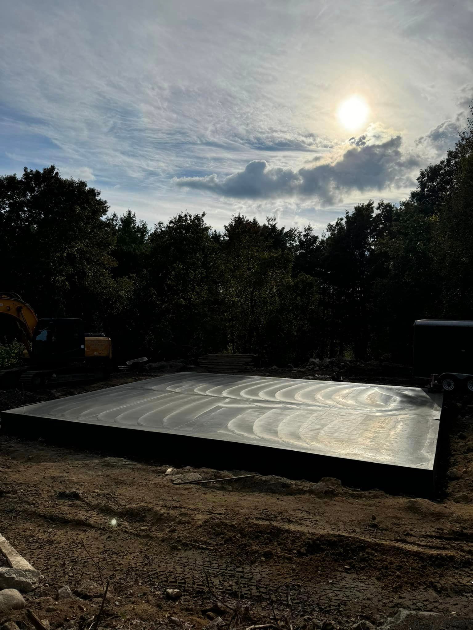 A large concrete slab is sitting in the middle of a dirt field.