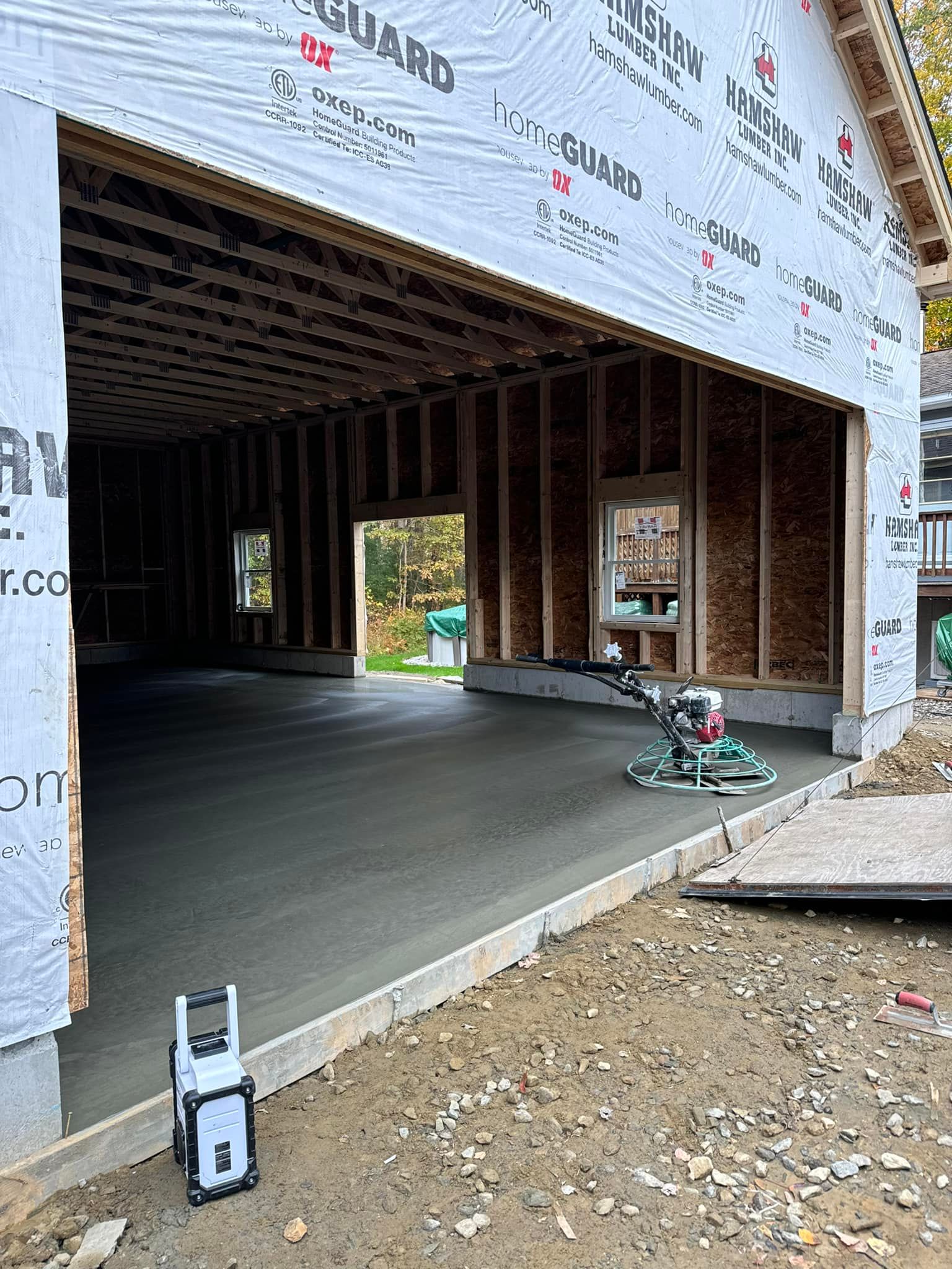 A concrete floor is being finished in a garage under construction.