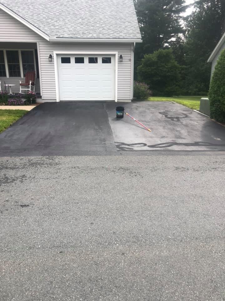 A house with a white garage door and a black driveway.