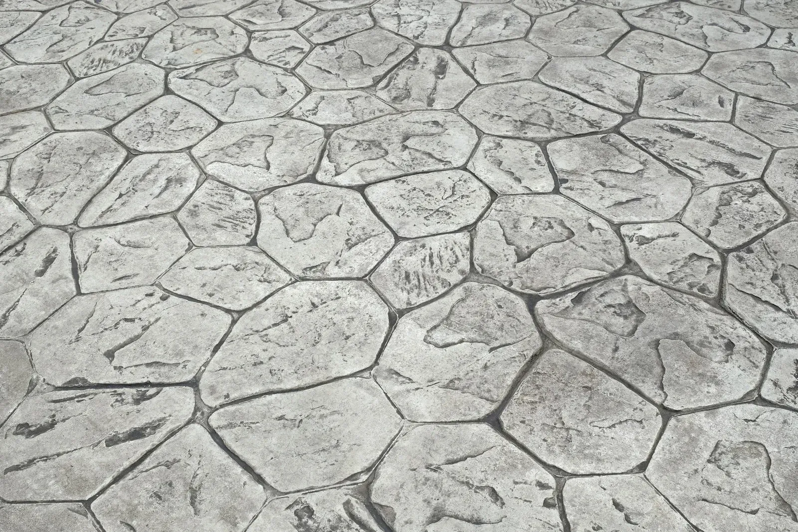 Gray stamped concrete pavement with irregular, stone-like shapes.