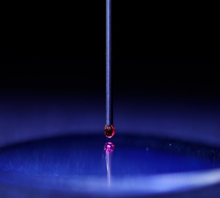 Una gota de líquido cae en un recipiente azul.