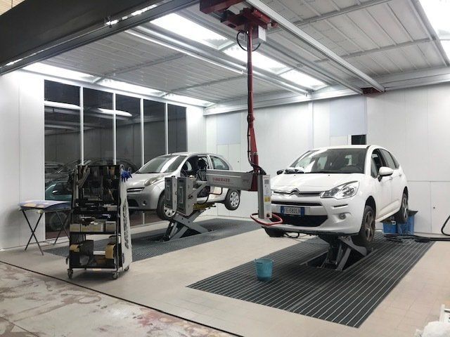 Due auto su ponti sollevatori all'interno