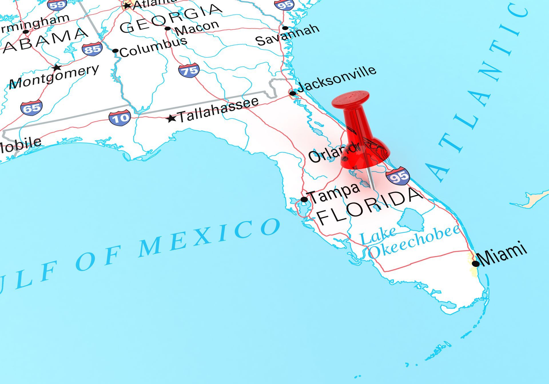 Red pushpin on Florida map near Orlando and Miami, beside the Gulf of Mexico and Atlantic Ocean