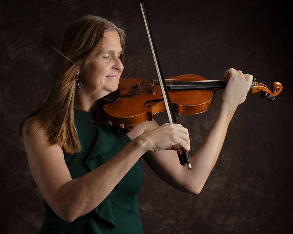 Een vrouw in een groene jurk speelt viool