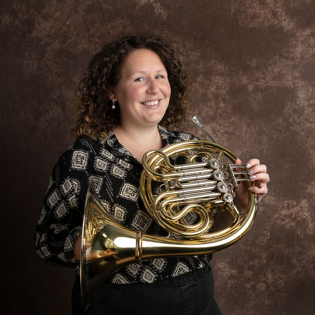 Een vrouw houdt een hoorn in haar handen en lacht.