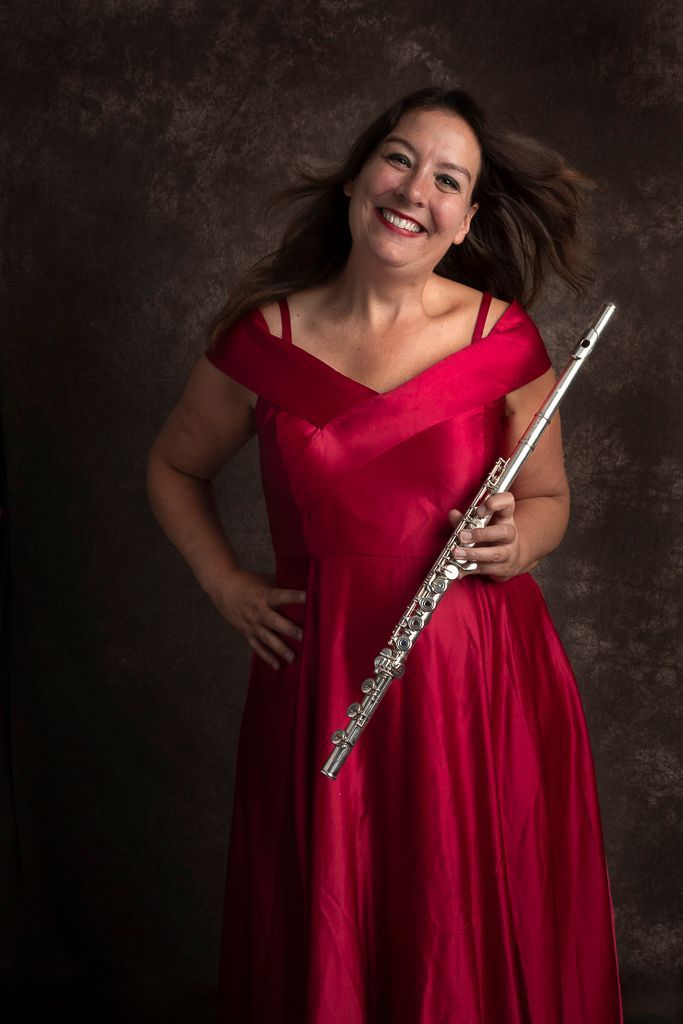 Een vrouw in een rode jurk houdt een fluit vast