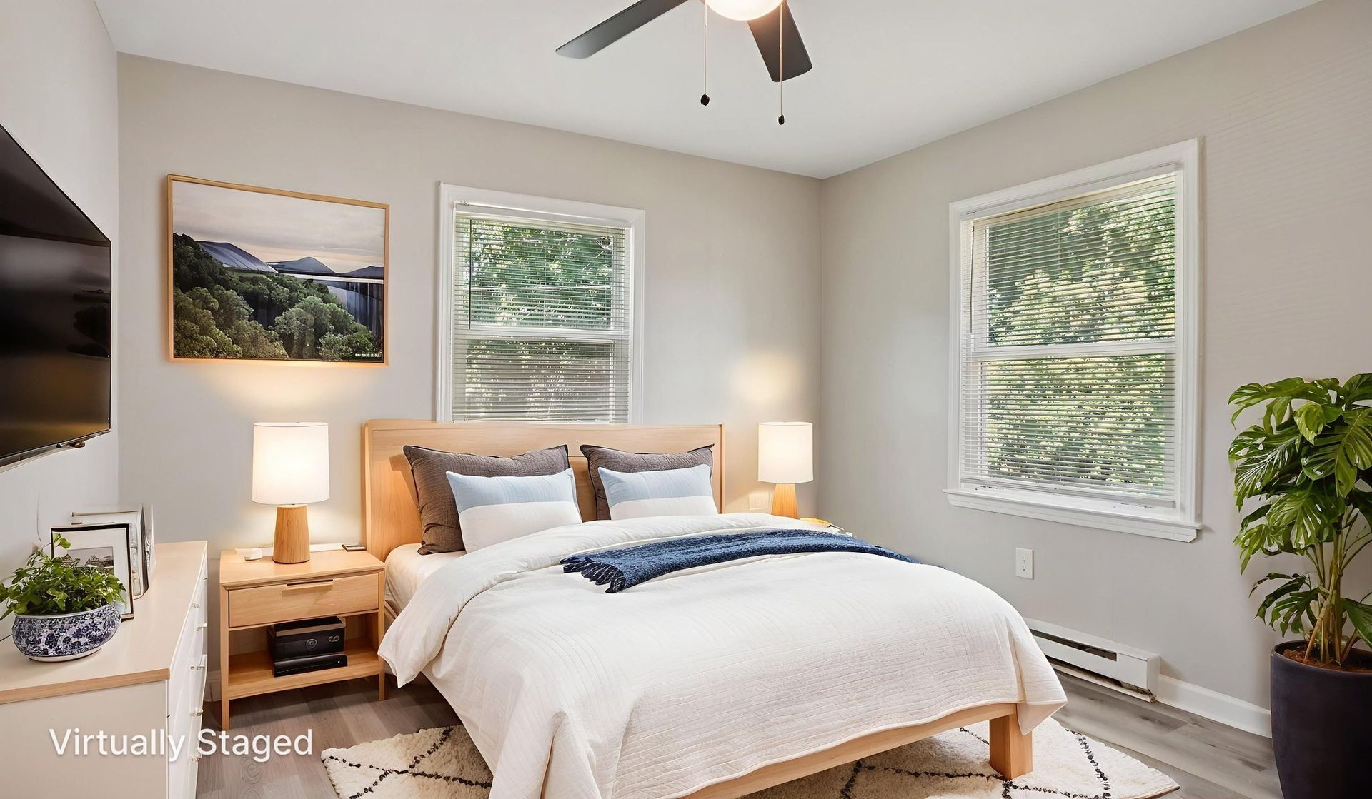 Bedroom with bed, nightstands, windows, art, and a plant. Neutral tones, modern decor.