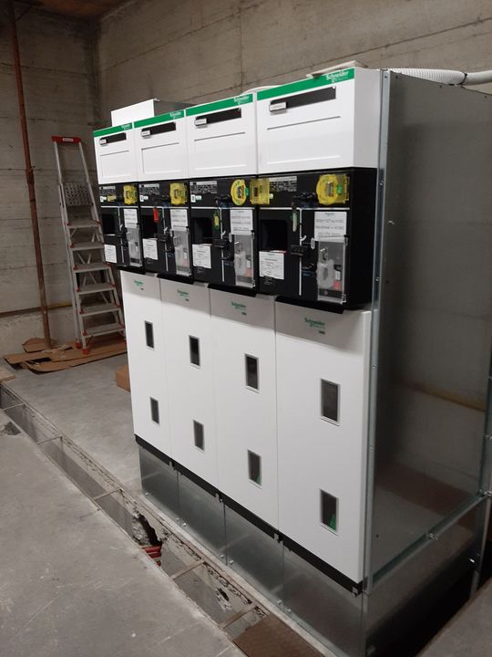 Armadio elettrico industriale in un locale di servizio, con contatori ed etichette sul pannello frontale.