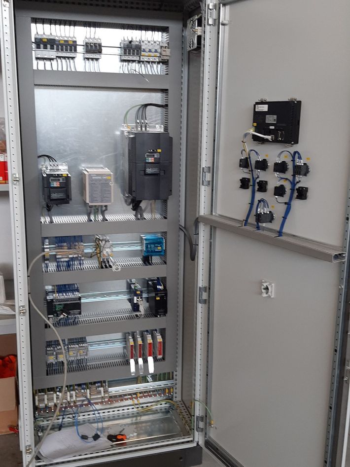 Armadio elettrico aperto con cablaggio, relè e pannello di controllo montato sulla porta.