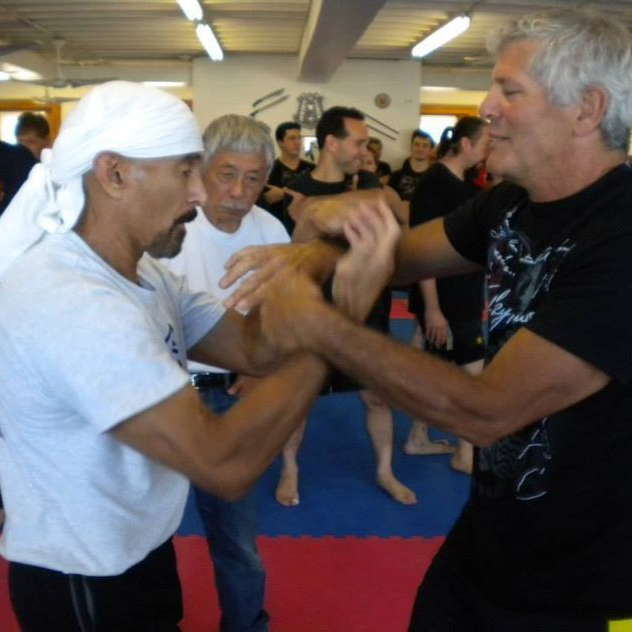 a group of men are practicing martial arts in a gym