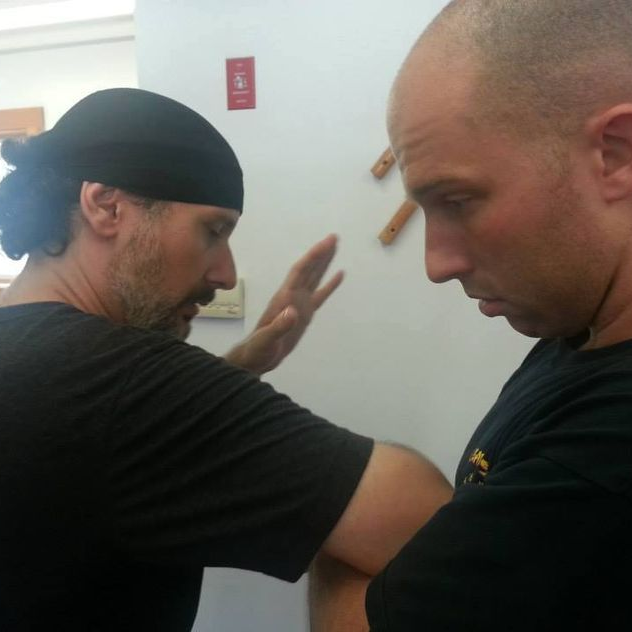 two men are standing next to each other and one has a bandana on his head