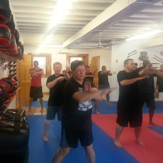 a group of men are practicing martial arts in a gym