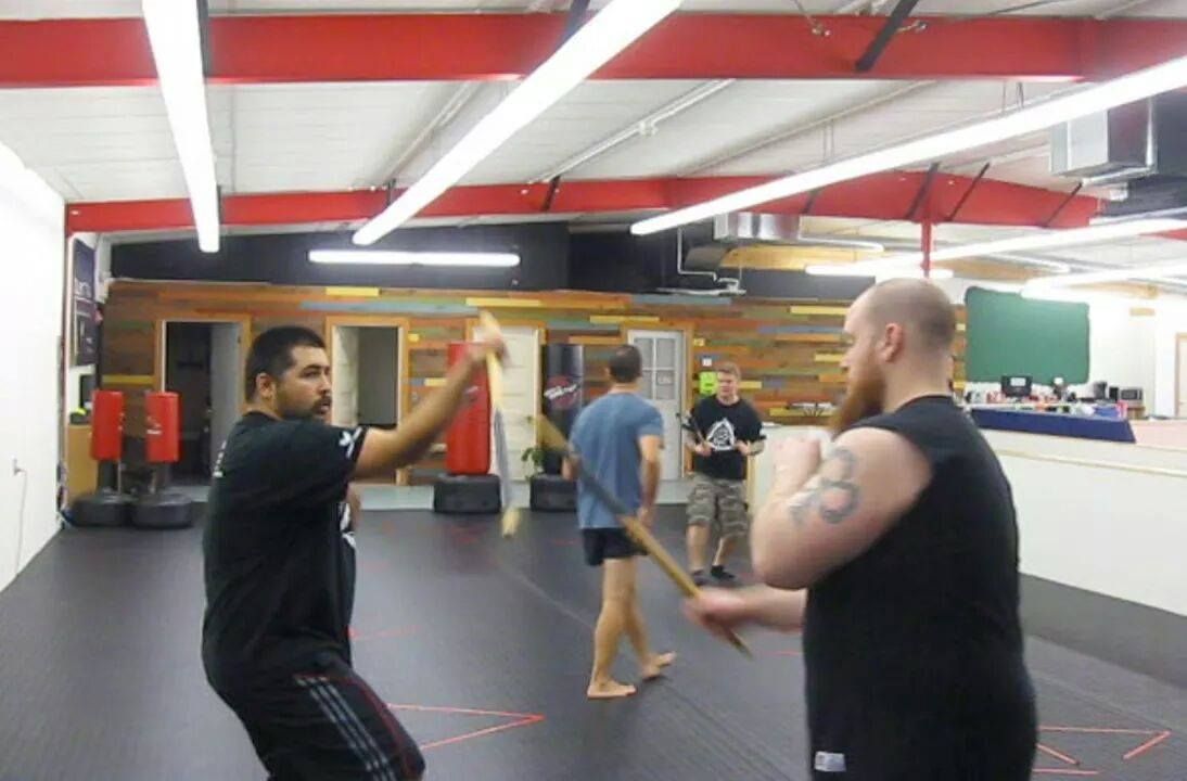 a group of men are practicing martial arts in a gym