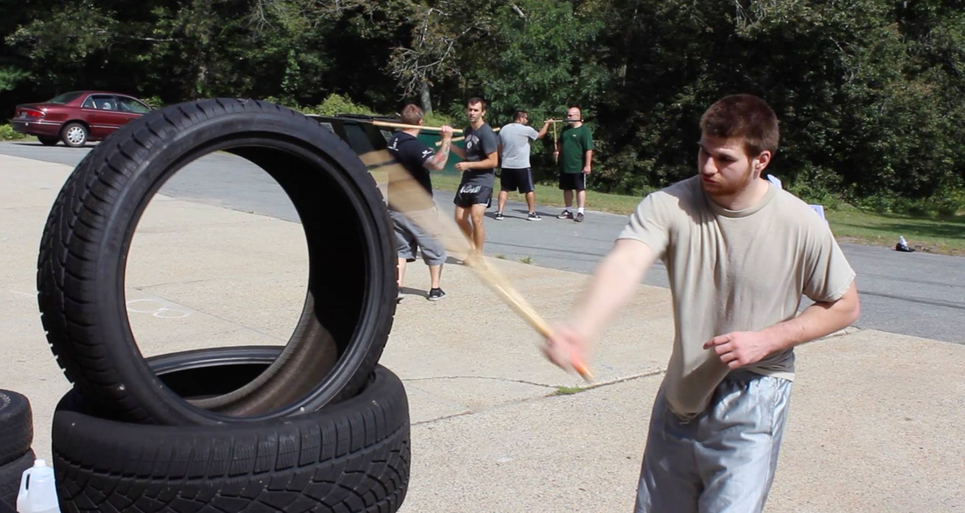 man hitting a tire wit ha kali stick