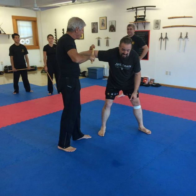 a group of people are practicing martial arts in a gym