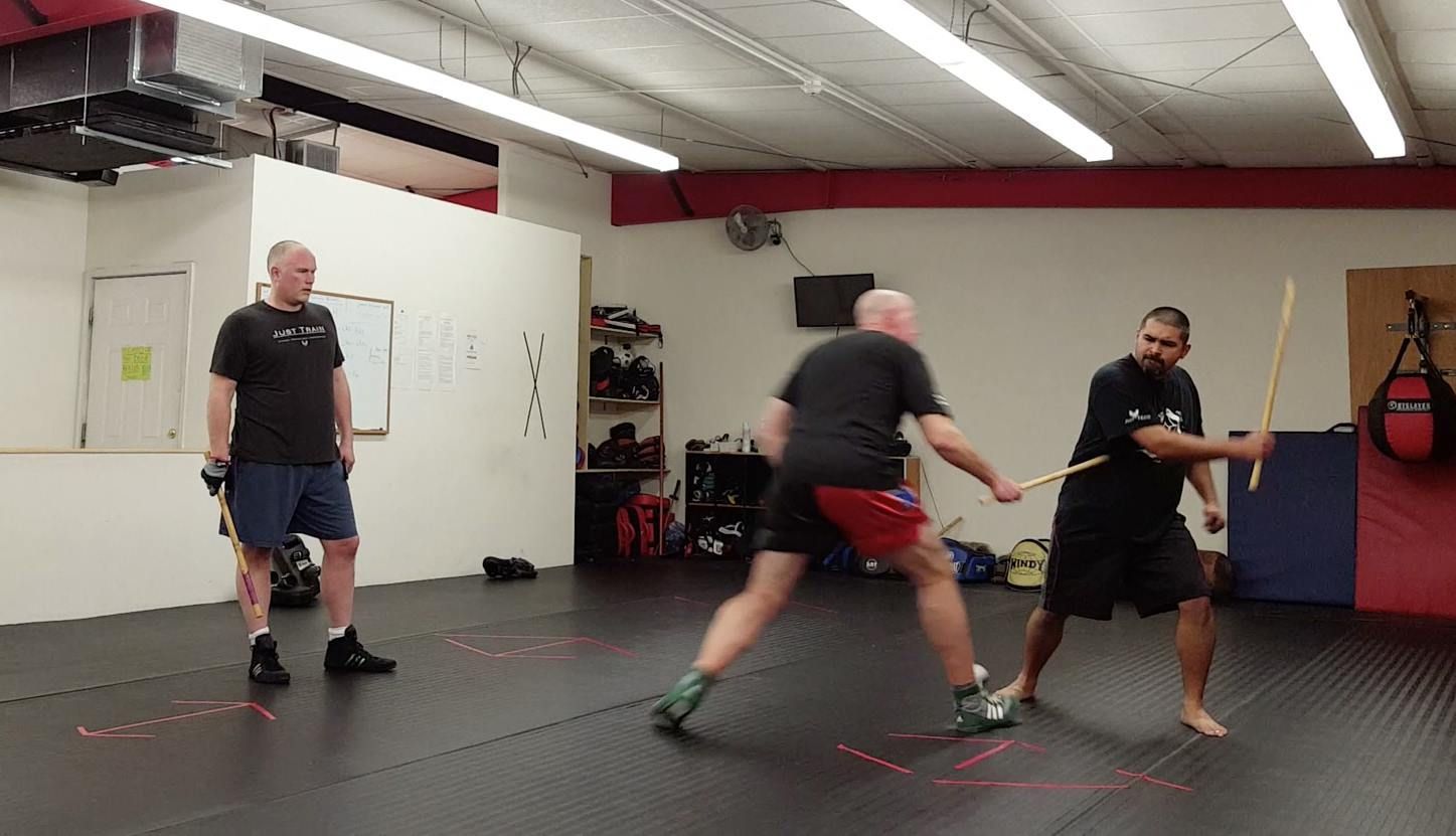 a group of men are practicing martial arts in a gym .