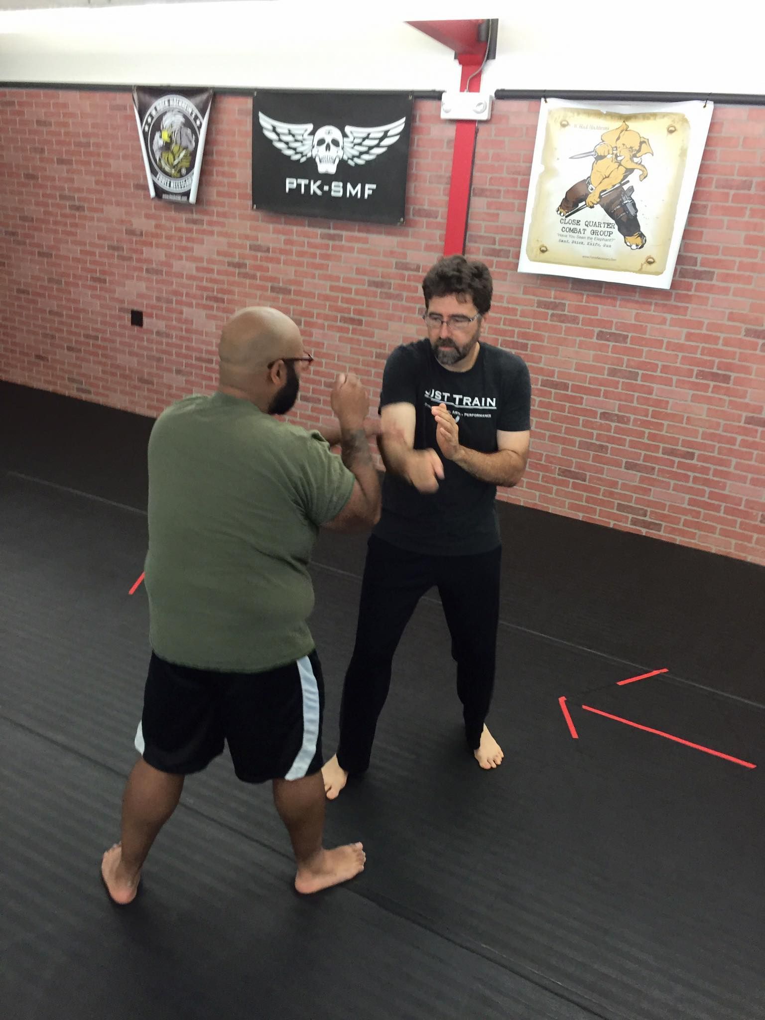 two men are practicing martial arts in a gym .