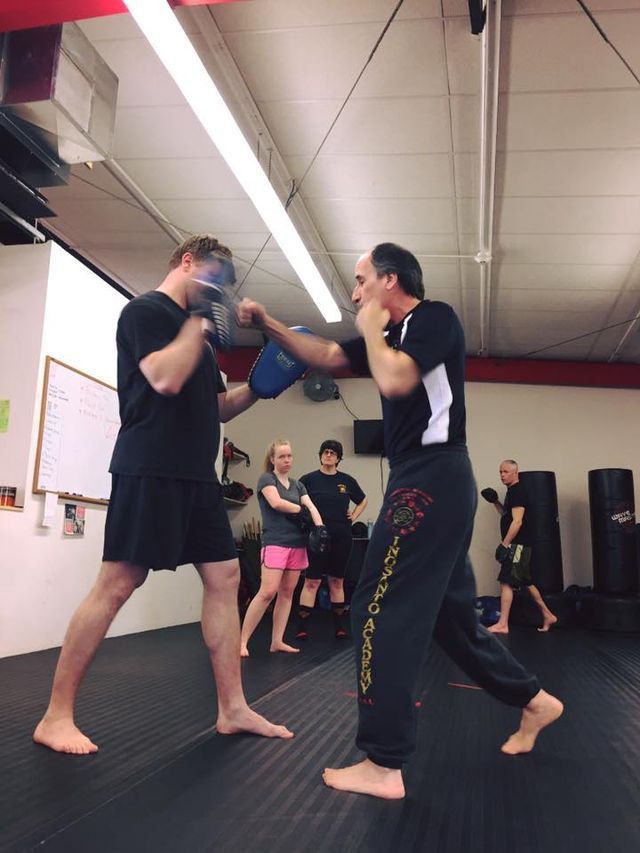 a group of people are practicing martial arts in a gym