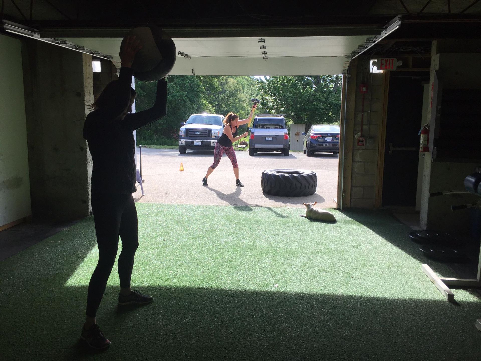 A female working out with a medicine ball in a garage