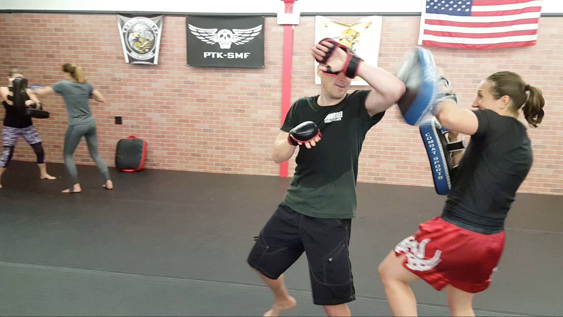 a man and a woman are boxing in a gym .