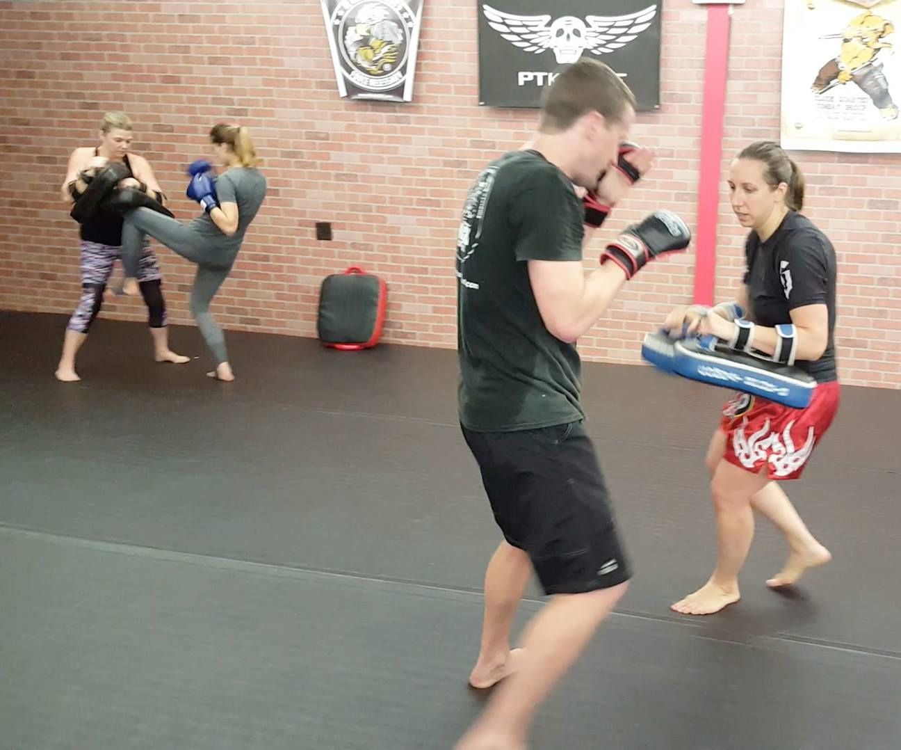 a group of people are practicing martial arts in a gym