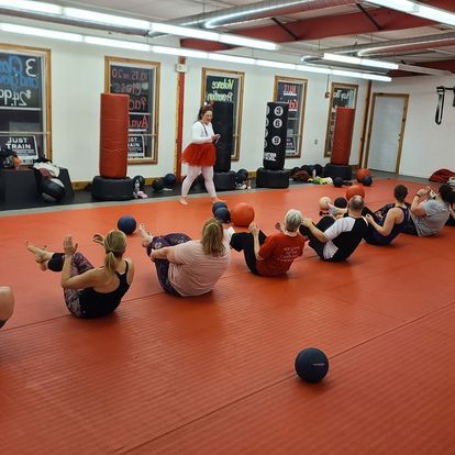 a group of people are doing exercises on the floor in a gym