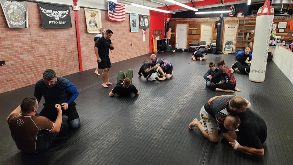 a group of people are practicing martial arts in a gym .