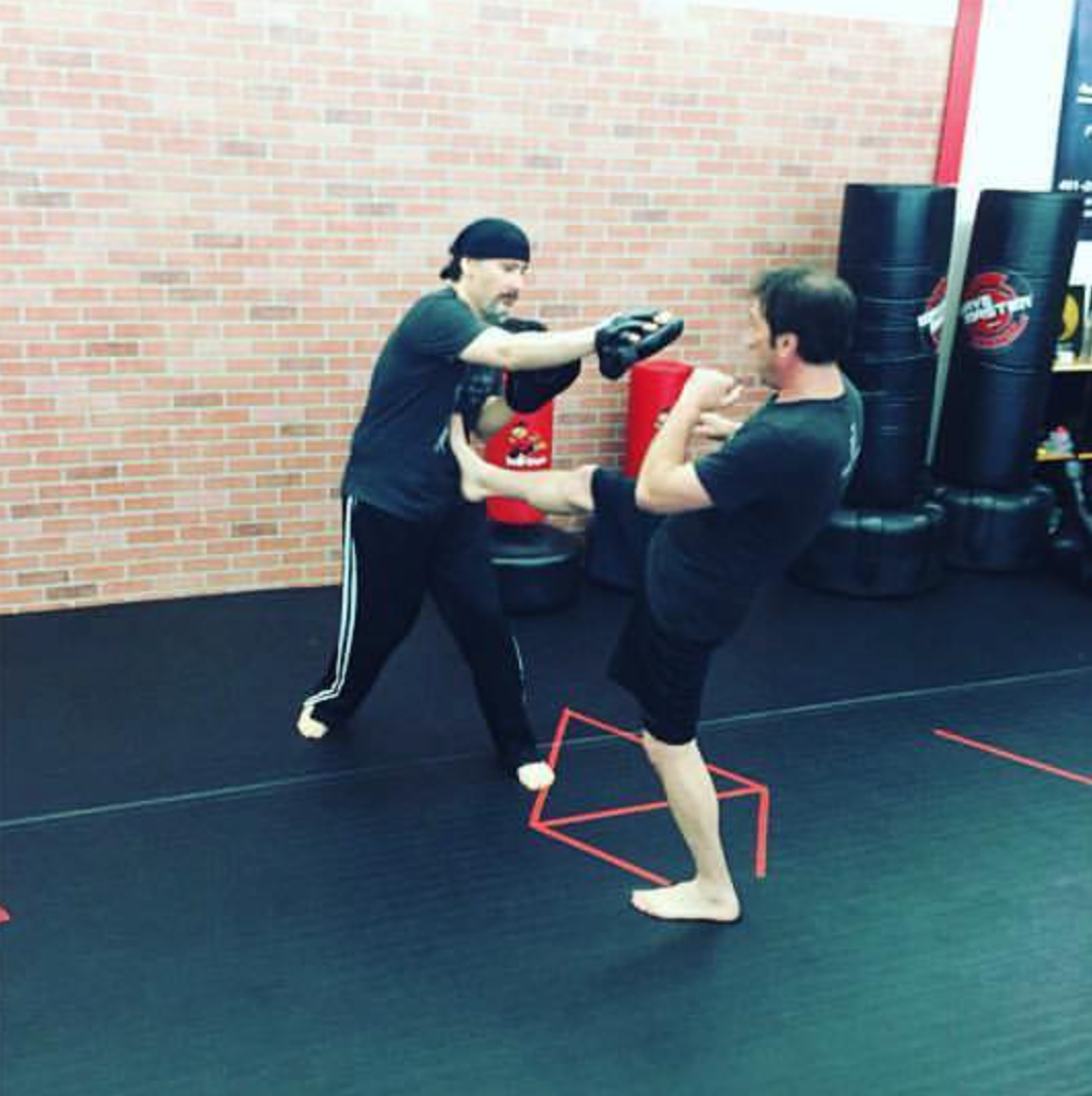 two men are practicing martial arts in a gym