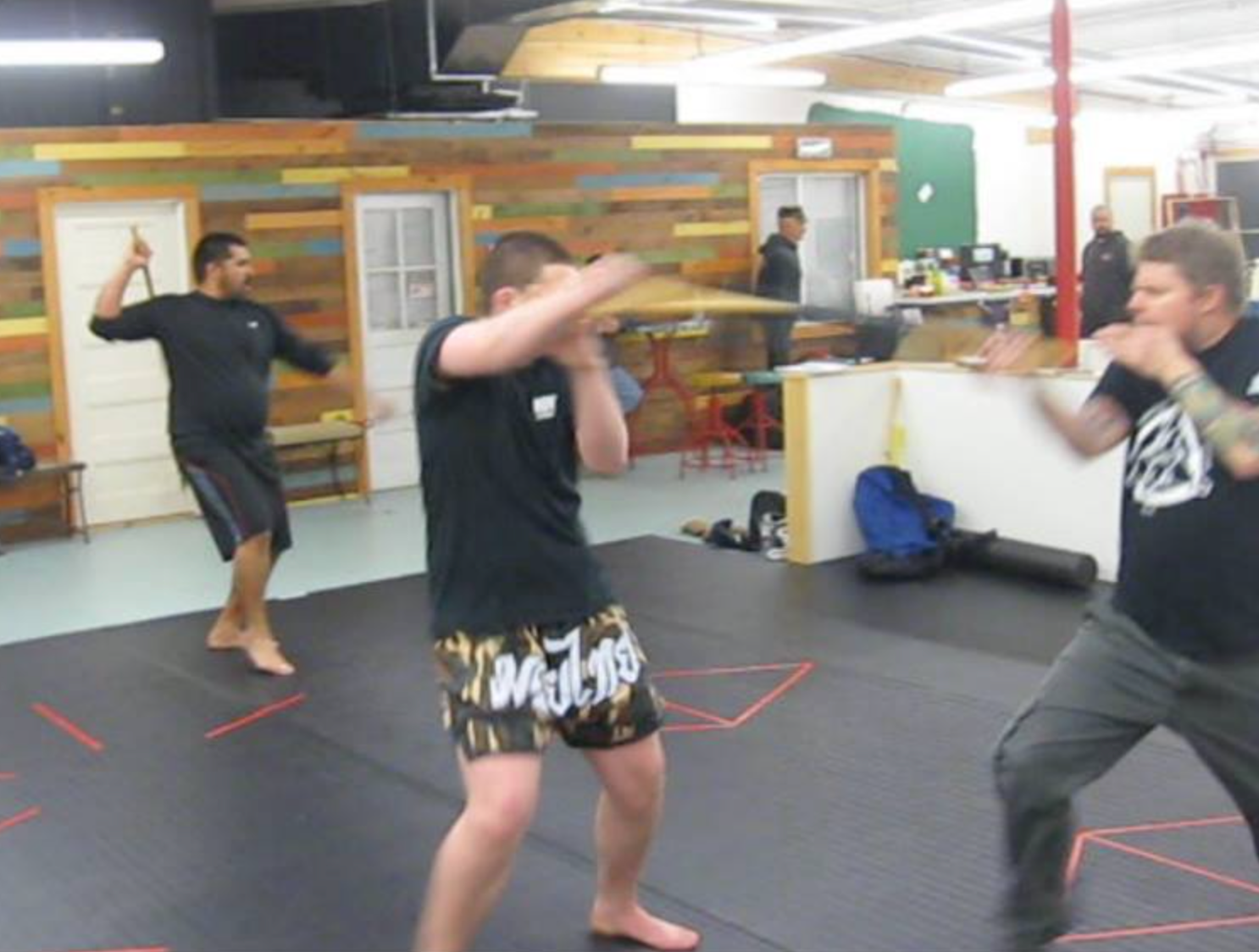 a group of men are practicing martial arts in a gym
