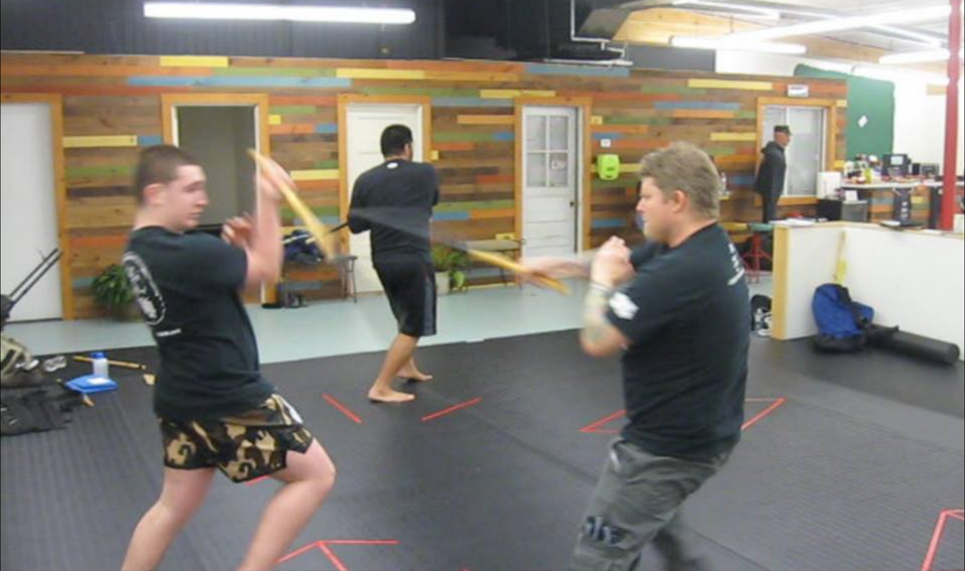 a group of men are practicing martial arts in a gym .
