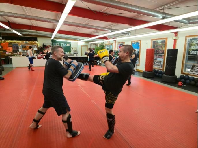 a group of men are practicing martial arts in a gym