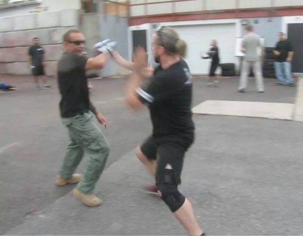 a man in a black shirt is talking to an older man in a white shirt