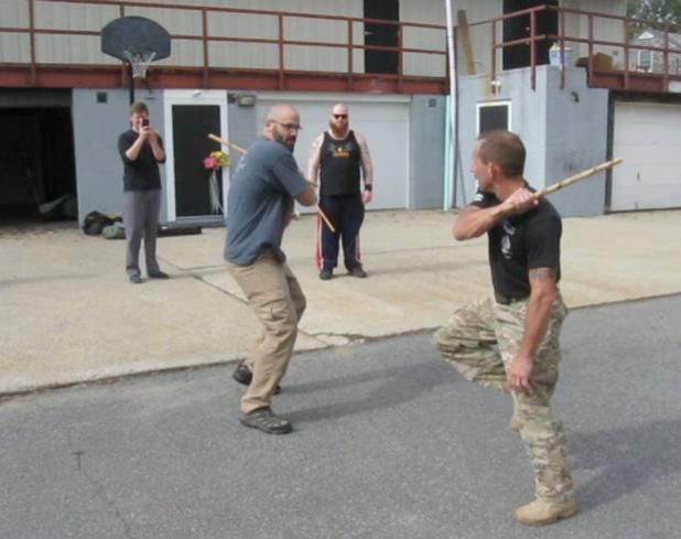 a group of people are standing in a room with one man wearing a shirt that says ' karate ' on it